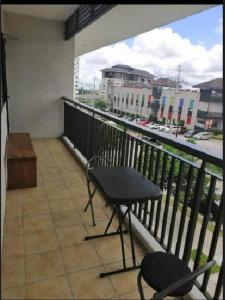 a balcony with a table and chairs and a view of a city at SERIN WEST TAGAYTAY-Spacious & Comfy 2BR Unit with Parking and Balcony in Tagaytay