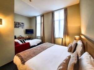 a hotel room with a large bed and a window at Hotel de Flandre Ghent in Ghent