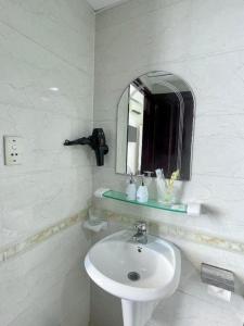 a white bathroom with a sink and a mirror at Anh Thien Sai Gon Central Hotel - by Bay Luxury in Ho Chi Minh City