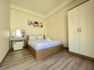 a bedroom with a bed and a dresser with a mirror at Anh Thien Sai Gon Central Hotel - by Bay Luxury in Ho Chi Minh City