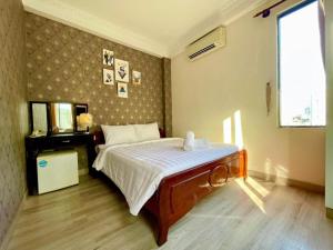 a bedroom with a bed and a television in it at Anh Thien Sai Gon Central Hotel - by Bay Luxury in Ho Chi Minh City