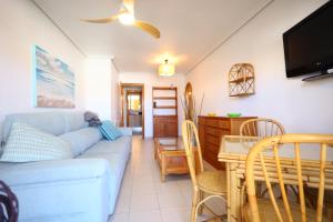 a living room with a blue couch and a table at 2 bedroom apartment at beach Dehesa de Campoamor in Dehesa de Campoamor
