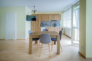 a dining room with a wooden table and chairs at Stara Piekarnia - Studio Dworcowa in Olsztyn