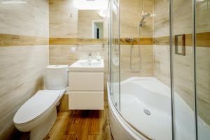 a bathroom with a toilet and a sink and a shower at Stara Piekarnia - Studio Dworcowa in Olsztyn