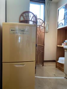 a kitchen with a yellow refrigerator in a room at Uchihan in Nozawa Onsen