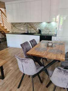 une cuisine avec une table et des chaises en bois dans l'établissement Apartament w sosnowym lesie, à Międzywodzie
