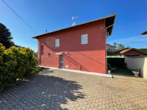 a red building with a driveway in front of it at La Spolina B&B in Cossato