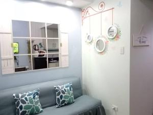 uma sala de estar com um sofá azul e um espelho em NEAREST MALL of ASIA Resort-facing 1BR fast wifi em Manila