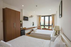 una camera d'albergo con due letti e una finestra di SeaColor Beachstay Danang Hotel by Haviland a Da Nang