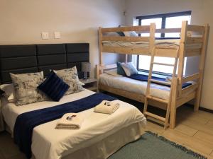 Riekert's Self-Catering Apartment في سواكوبموند: غرفة نوم بسريرين بطابقين وسلم