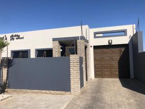 a house with a gate and a garage at Riekert's Self-Catering Apartment in Swakopmund