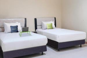 Ένα ή περισσότερα κρεβάτια σε δωμάτιο στο Urbanview Hotel Istana Bangun Jagad Indramayu by RedDoorz