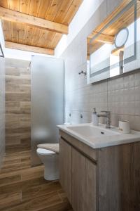 a bathroom with a sink and a toilet and a mirror at Piedra Residence in Pigi