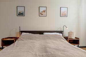 a bedroom with a bed with three pictures on the wall at Apartament Classic Spa&Wellness by Major Domus Club in Dziwnów +18 photos