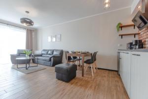 a living room with a couch and a table at Apartament Classic Spa&Wellness by Major Domus Club in Dziwnów