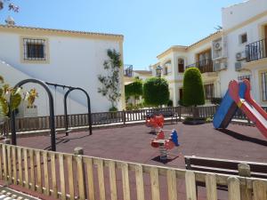 un parque infantil frente a un edificio con tobogán en Superior Vera Beach en Vera