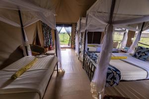 a room with two beds in a tent at Serengeti Wildebeest Camp in Banagi