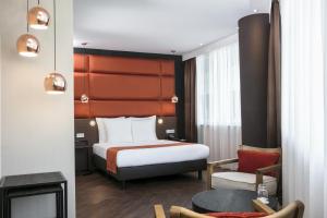 ein Hotelzimmer mit einem Bett und einem Stuhl in der Unterkunft Holiday Inn Amsterdam - Arena Towers, an IHG Hotel in Amsterdam