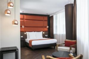 um quarto de hotel com uma cama e uma cadeira em Holiday Inn Amsterdam - Arena Towers, an IHG Hotel em Amsterdã