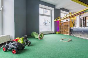 - une chambre pour enfants avec un tapis vert et des voitures jouets dans l'établissement a&o Dortmund Hauptbahnhof, à Dortmund