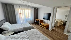 ein Hotelzimmer mit 2 Betten und einem Schreibtisch in der Unterkunft LAWENDOWE NOCOWANIE Główna 19 lok11 in Kudowa-Zdrój