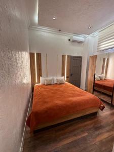 a bedroom with a large orange bed with two pillows at Dream Hotel in Almaty