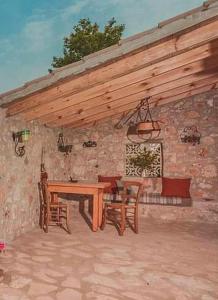 a wooden table and chairs in a stone building at La Casa Di Nonna in Koríthion