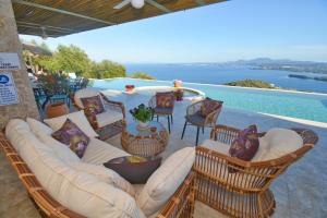 a patio with a couch and chairs and a view of the water at Summerwine Luxury Villa Sea View Private Pool in Spartýlas
