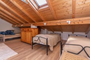 2 łóżka w pokoju z drewnianym sufitem w obiekcie Casa Narciso w mieście Rocca Pietore