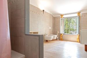 ein Badezimmer mit zwei Waschbecken, einer Badewanne und einem Fenster in der Unterkunft Villa Regno di Toscana in San Giuliano Terme