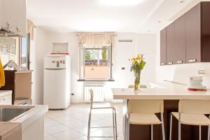 eine Küche mit einem weißen Kühlschrank und einem Tisch mit Stühlen in der Unterkunft Villa Regno di Toscana in San Giuliano Terme
