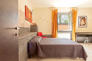 Schlafzimmer mit einem Bett, einem TV und einem Fenster in der Unterkunft Villa Regno di Toscana in San Giuliano Terme