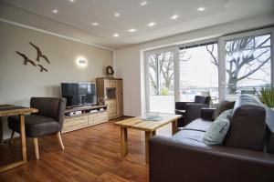 a living room with a couch and a tv at hafennahe Ferienwohnung mit Meerblick - Hafenresidenz Lauterbach FeWo 2-3 in Lauterbach