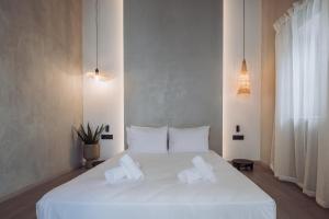 een slaapkamer met een wit bed en 2 handdoeken bij Kilistra Lindian Living in Lindos