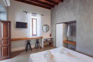 a bedroom with a bed and a desk and a mirror at Kilistra Lindian Living in Lindos