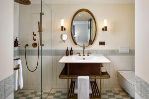 a bathroom with a sink and a mirror at Small Luxury Hotel Ambassador Zurich in Zurich