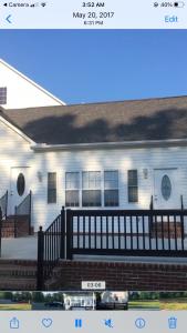 una casa blanca con una valla negra delante de ella en MooreField Suites Greensboro East, en McLeansville