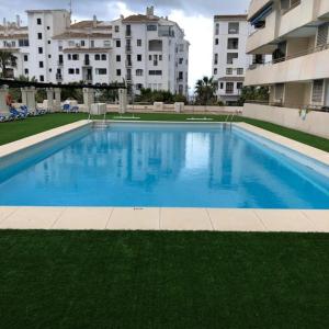 a large swimming pool in front of some buildings at Marina Banus in Marbella