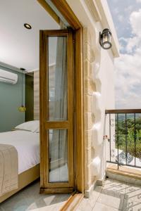 um quarto com uma cama e uma porta de vidro em Alonion Apartments em Yerakianá