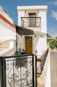uma casa branca com uma varanda e uma porta em Alonion Apartments em Yerakianá