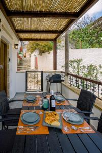 uma mesa com pratos de comida e vinho num pátio em Alonion Apartments em Yerakianá