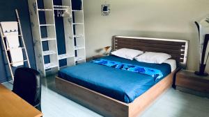 億唐塞拉的住宿－Le Dodo Salé，一间卧室配有一张带蓝色床单和白色枕头的床。