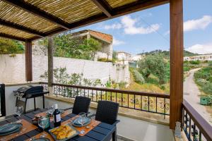 a table and chairs on a balcony with a view at Alonion Apartments in Yerakianá