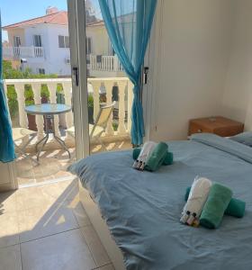 阿依纳帕Nissi Beach Golden Villas的一间卧室配有带枕头的床铺和阳台 更多13张照片