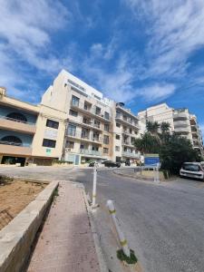セントジュリアンズにあるKORZO SUITES ST. JULIAN`Sの大きな建物前の空き道