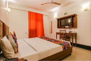 a bedroom with a bed and a desk and a television at FabHotel JDM Residency in Gurgaon +18 photos