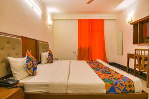 um quarto com uma cama grande em frente a uma janela em FabExpress JDM Residency em Gurgaon
