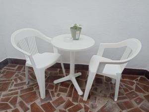 two white chairs and a table with a potted plant on it at Mi Piriposa in Valverde