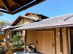 a house with a yellow door and a dog in front at Kyoto Ryokan Gion Sano in Kyoto