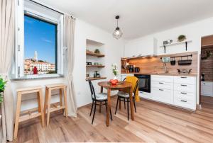 a kitchen with a table and chairs and a window at Perla Adriatica in Rovinj